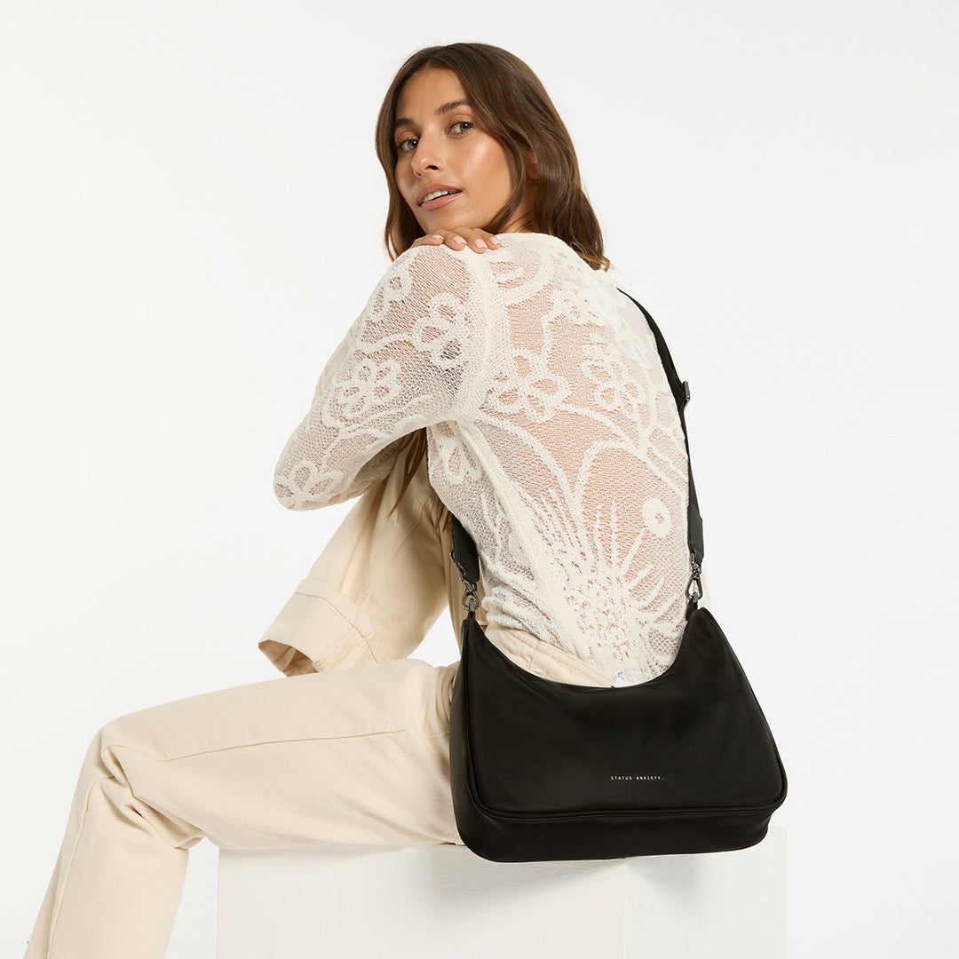 https://cdn.shopify.com/s/files/1/0214/8218/files/status-anxiety-bag-poly-fleur-black-3-lifestyle-img.jpg?v=1770763823